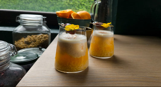Deux verres d'un cocktail sans alcool qui associe le jus d'orange, la fleur d'oranger, la datte et le lait d'amande
